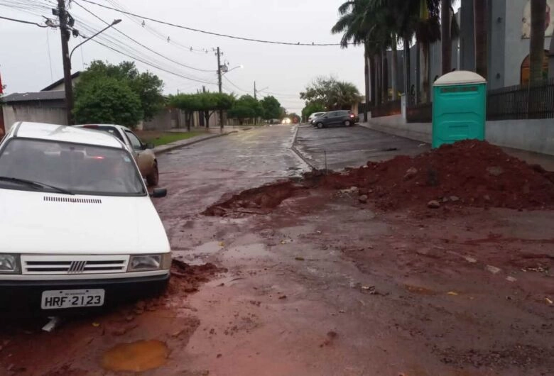 Idosa fica com carro preso em valeta de obra após chuva em Dourados